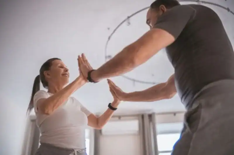 Cuidados com os idosos: 5 atitudes essenciais para garantir qualidade de vida na terceira idade 6 Idosa realizando exercícios de fisioterapia e recebendo cuidados com os idosos em São Paulo